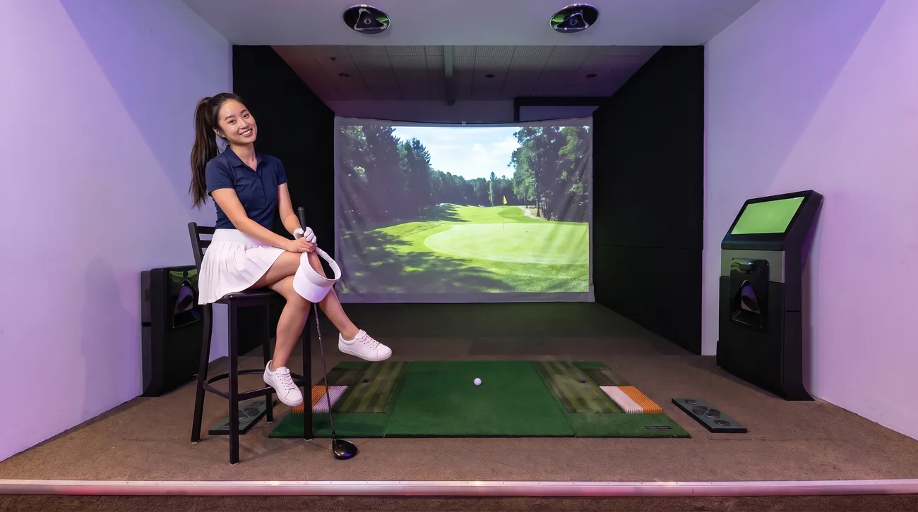 A woman on a stool beside the simulator screen